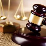 A wooden gavel and scales of justice on a table