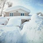 A house surrounded by deep snow drifts after a heavy snowfall