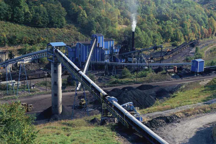 Industrial coal processing plant with conveyor belts and smokestack.