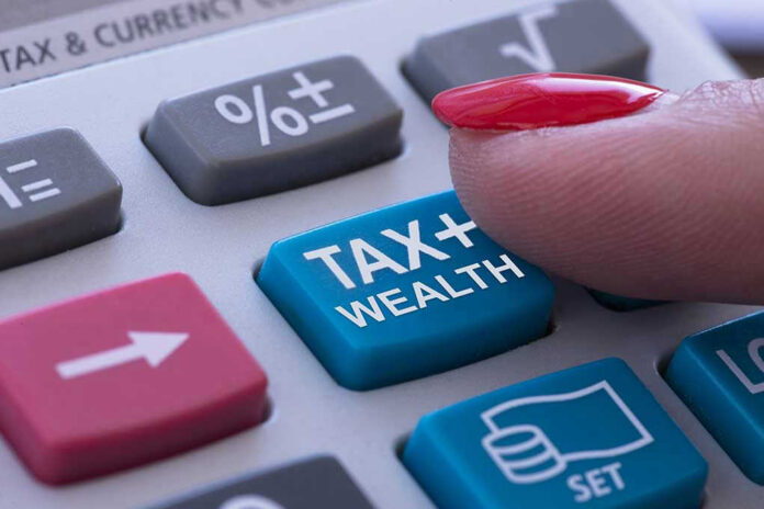 1762066592 Finger pressing calculator tax and wealth button