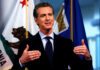 Newsom SEIZES Family Wealth — No Compensation Man speaking with flags in the background