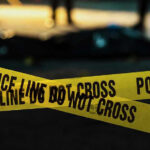 Police tape marking a crime scene at night.