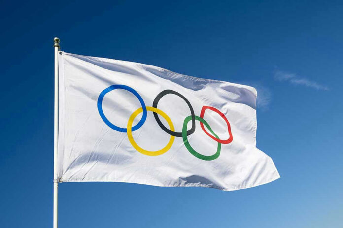 430080421 Olympic flag waving against clear blue sky.