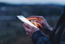 Leaked EXPLICIT Late-Night Texts Rock GOP Person using a smartphone at dusk.