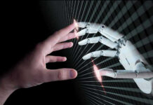 Human and robotic hands almost touching fingers.