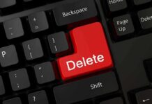 Close-up of a black computer keyboard featuring a prominent red delete key