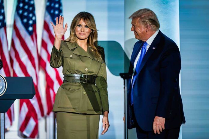 A couple at a political event, with one waving and the other looking on