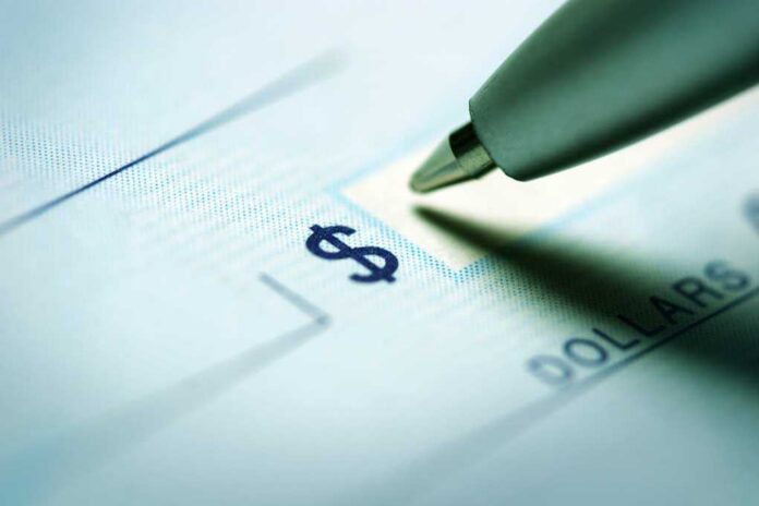 Close-up of a pen poised over a check with a dollar sign