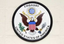 Seal of the United States Embassy featuring an eagle and the American flag