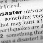 Close-up of a dictionary page showing the definition of the word 'disaster'