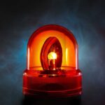 An illuminated orange emergency light on a dark background