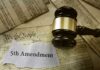 A gavel resting on legal documents with the text 5th Amendment