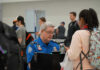 TSA agent checks passengers documents at airport security.