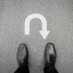 UNBELIEVABLE U-TURN–7 NATIONS Say YES To Trump Feet in black shoes facing U-turn road marking.