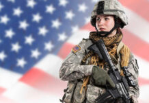 Soldier in uniform with USA flag background.