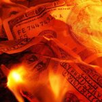 Burning U.S. dollar bills surrounded by flames
