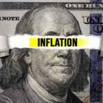 A hundred dollar bill with the word INFLATION prominently displayed across it