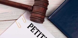 A gavel resting on a legal petition document with a pen and folder