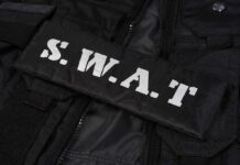 Beachfront Murder Sparks SWAT Siege Close-up of a SWAT uniform patch on black tactical gear