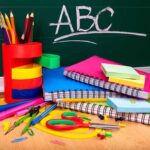 A collection of colorful school supplies including notebooks, pens, and scissors on a desk