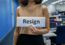 Person holding a sign that says resign