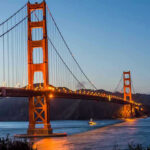 Golden Gate Bridge at dusk with lights on.