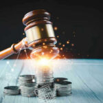 Gavel, coins, and tax icons on a table.