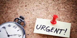Pocket watch and urgent note pinned on corkboard