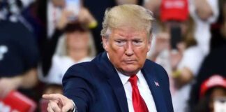 A speaker at a rally pointing towards the audience