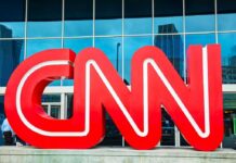 Large red CNN logo in front of a glass building