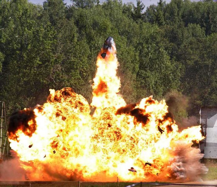 A large explosion with flames and smoke in an outdoor setting