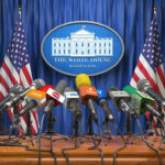 Trump’s Iran Deal TWIST – What’s the CATCH? Multiple microphones at White House press briefing podium.