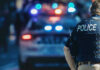 Freed Felon Wreaks Havoc 3 Days Later Police officer with patrol car and flashing lights.