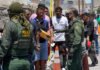 Border Sparks FURY: Controversy Escalates Border patrol agents inspecting group of individuals in line.