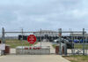 Chain-link fence with Restricted Area Stop No Photography sign.