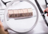 Fraud blocks under magnifying glass on invoices.