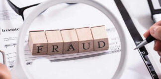 Fraud blocks under magnifying glass on invoices.