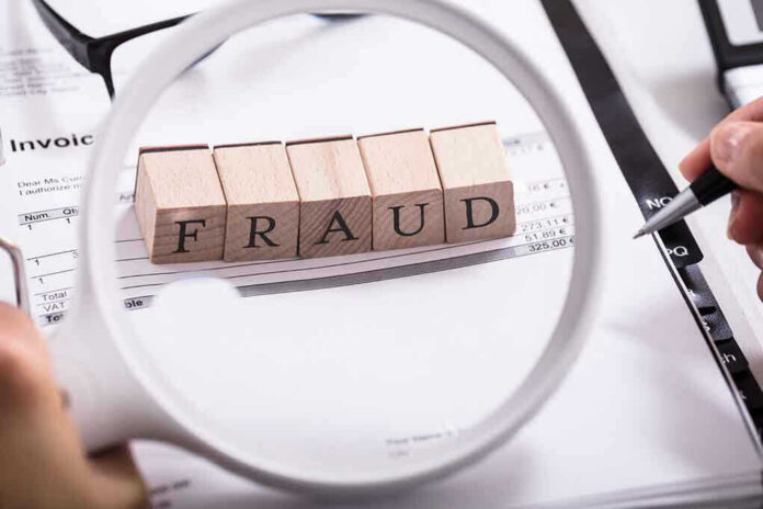 792864664 Fraud blocks under magnifying glass on invoices.