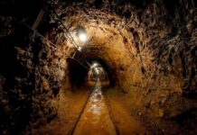 Gas Sensor Ignored? OVER 82 VANISH in BLAST Dimly lit underground tunnel with rail tracks and rocky walls