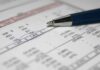 Close-up of a financial document with highlighted numbers and a pen
