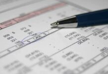 Close-up of a financial document with highlighted numbers and a pen