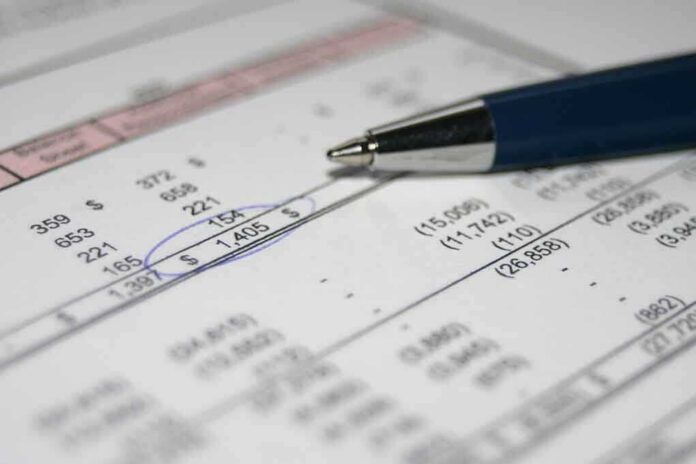 Close-up of a financial document with highlighted numbers and a pen