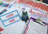 California Eyes Lower Billionaire Tax to Fund Healthcare Voter registration table with forms, pens, and brochures.