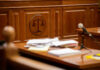 Attorneys Ousted Over AI Citation Errors Wooden courtroom desk with papers and a microphone.
