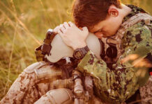 Officer’s Film Forces Attention on Military Sexual Trauma Crisis Soldier sitting, leaning head on helmet.