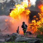 3 Firefighters Killed as Wildfire Turns Into Deadly Firefighter battling a large fire with water spray