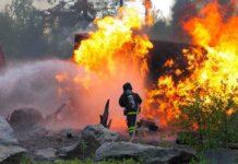 3 Firefighters Killed as Wildfire Turns Into Deadly Firefighter battling a large fire with water spray