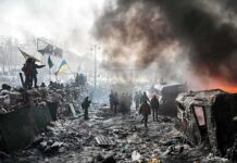 A chaotic protest scene with smoke, fire, and people holding flags