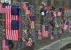 Memorial Backlash Explodes on the Mall Memorial wall adorned with American flags and flowers