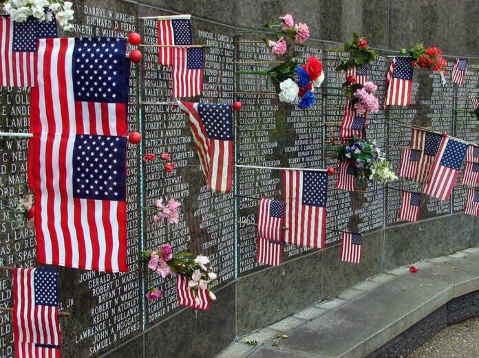 Memorial wall adorned with American flags and flowers